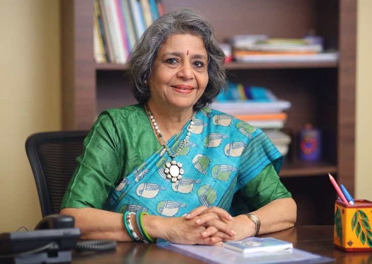 Mrs.-Malati-Kalmadi Woman in traditional attire at desk.